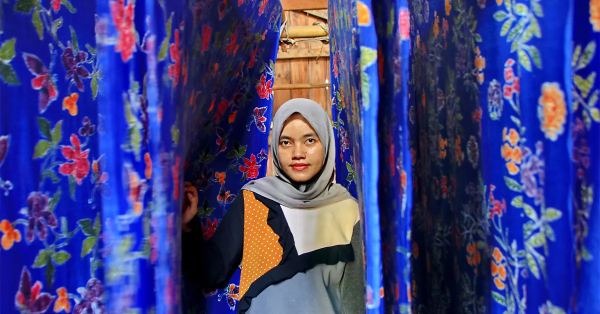 a woman who is drying colored batik cloth, directly in the sun, Pekalongan, Indonesia,